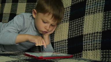 Dijital tablet üzerinde oyun oynayan çocuk