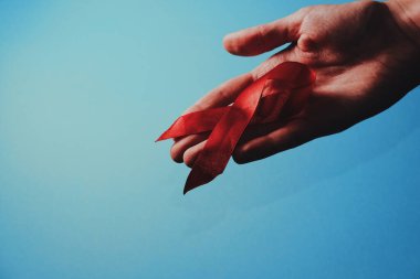 Sağlık ve tıp konsepti - kırmızı yardım kurdelesi tutan kadın eli