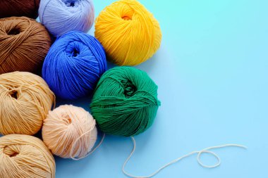 Mavi arkaplanda parlak renk iplikçikleriyle yapılmış. Amigurumi oyuncağı yapma kavramı, el işi, örgü, hobi. Posterler için kullanılabilir