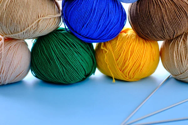 Mavi arkaplanda parlak renk ipliği demetleri. Amigurumi oyuncağı yapma kavramı, el işi, örgü, hobi