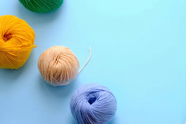 Mavi arkaplanda parlak renk iplikçikleriyle yapılmış. Amigurumi oyuncağı yapma kavramı, el işi, örgü, hobi. Posterler için kullanılabilir