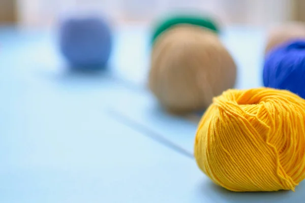 Mavi arkaplanda parlak renk ipliği demetleri. Amigurumi oyuncağı yapma kavramı, el işi, örgü, hobi.