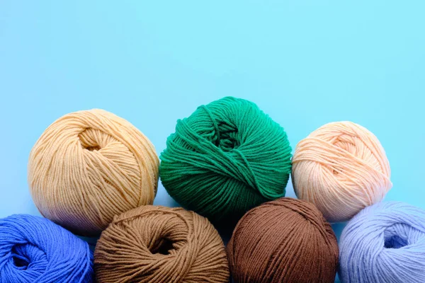 Helle Farbigkeit Garn Clews auf dem blauen Hintergrund. Konzept der amigurumi Spielzeugherstellung, Handarbeit, Hobby — Stockfoto