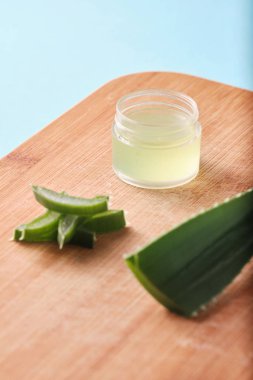 aloe vera dilimleri ve merhem kutusu, kremalı aloe vera yaprağı bambu kesim yüzeyi
