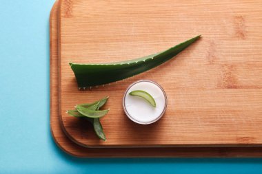 Düz konum aloe vera yaprak kremi, solda telif alanı olan yakın çekim yassı kaplama, sağlık hizmeti fayda kavramı