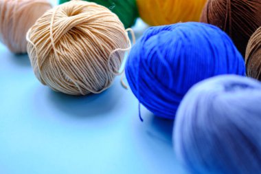 Mavi arkaplanda parlak renk ipliği demetleri. Amigurumi oyuncağı yapma kavramı, el işi, örgü, hobi
