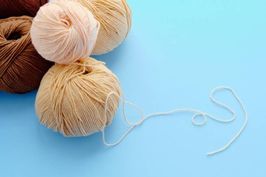 Mavi arkaplanda parlak renk iplikçikleriyle yapılmış. Amigurumi oyuncağı yapma kavramı, el işi, örgü, hobi. Posterler için kullanılabilir