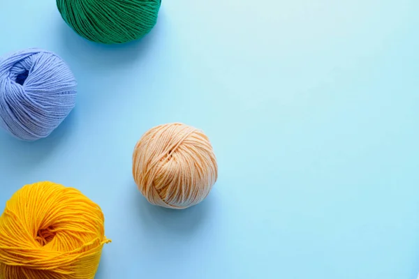 Mock-up made with bright color yarn clews on the blue background. Concept of amigurumi toy making, handicraft, knitting, hobbie. Can be used for posters — Stock Photo, Image