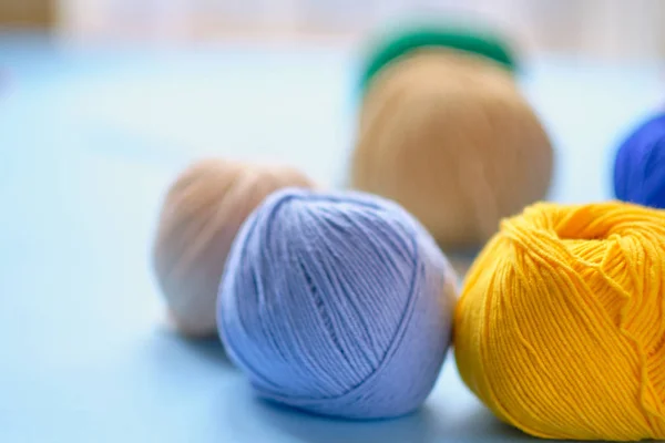 Mavi arkaplanda parlak renk ipliği demetleri. Amigurumi oyuncağı yapma kavramı, el işi, örgü, hobi