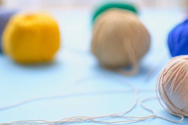 Mavi arkaplanda parlak renk ipliği demetleri. Amigurumi oyuncağı yapma kavramı, el işi, örgü, hobi