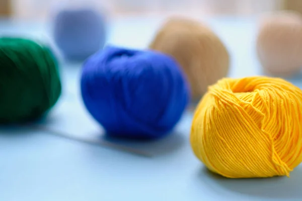 Mavi arkaplanda parlak renk ipliği demetleri. Amigurumi oyuncağı yapma kavramı, el işi, örgü, hobi.