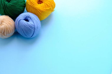 Mavi arkaplanda parlak renk iplikçikleriyle yapılmış. Amigurumi oyuncağı yapma kavramı, el işi, örgü, hobi. Posterler için kullanılabilir