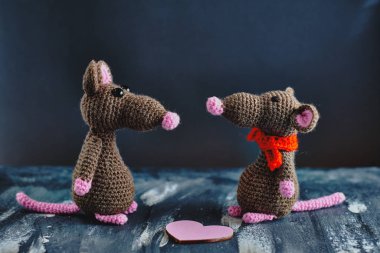 El yapımı amigurumi fareleri pembe kalbin yanında karşı karşıya duruyorlar. Sevgililer Günü, 14 Şubat, aşk, ilişkiler konsepti
