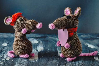 Güzel bir el yapımı amigurumi faresi başka bir oyuncak fareye pembe bir kalp hediye ediyor. Sevgililer Günü, 14 Şubat, aşk, ilişkiler konsepti.