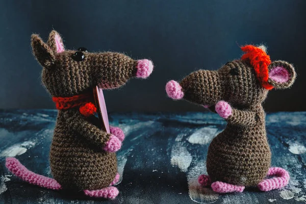 Güzel bir el yapımı amigurumi faresi başka bir oyuncak fareye pembe bir kalp hediye ediyor. Sevgililer Günü, 14 Şubat, aşk, ilişkiler konsepti.