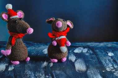 Mavi arka planda duran Noel şapkalı ve kırmızı eşarplı güzel el yapımı amigurumi fareleri. Yeni Yıl 2020 konsepti