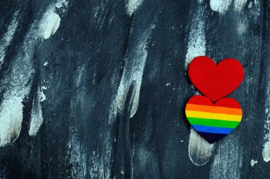 Kalbin üst görüntüsü soyut arkaplanda geleneksel kırmızı kalbe yakın Lgbt gurur renkleri ile renklendirildi. Sevgililer Günü konsepti.