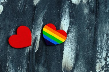 Kalbin üst görüntüsü soyut arkaplanda geleneksel kırmızı kalbe yakın Lgbt gurur renkleri ile renklendirildi. Sevgililer Günü konsepti.