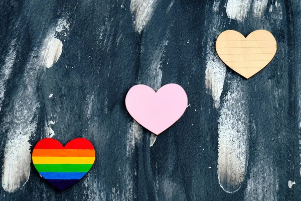 Vista superior del corazón coloreado en colores LGBT orgullo cerca del corazón rosa tradicional y aún no coloreado corazón en el fondo abstracto. Concepto de San Valentín . — Foto de Stock