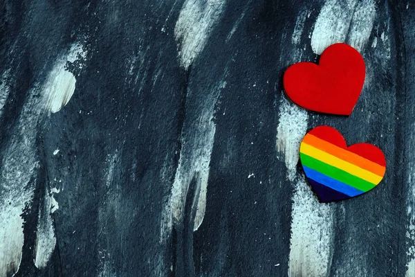 Vista superior del corazón coloreado en colores LGBT orgullo cerca del corazón rojo tradicional en el fondo abstracto. Concepto de San Valentín . — Foto de Stock