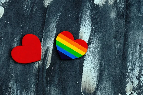 Draufsicht des in lgbt-stolzen Farben gefärbten Herzens in der Nähe des traditionellen roten Herzens auf dem abstrakten Hintergrund. Valentinstag-Konzept. — Stockfoto