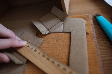 El ele tutuşan hükümdar, karton atıklardan diy projesi yapıyor.