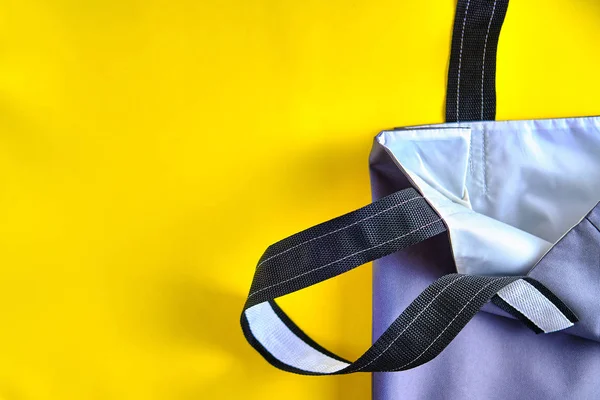 Açık alışveriş torbası, parlak sarı arka planda doğal malzemelerle yapılmış. Sıfır atık yaşam tarzı, ekoloji güvenliği, geri dönüşümlü atık, çevre koruması, Dünya günü kavramı.