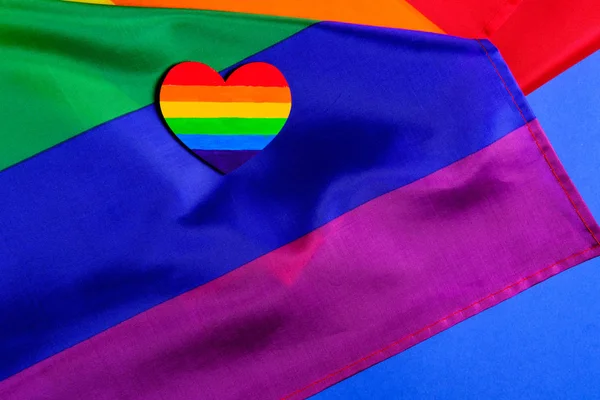 Maqueta hecha con la bandera del orgullo LGBT con el corazón coloreado en colores de orgullo LGBTQ. Concepto del día de San Valentín, libertad, igualdad — Foto de Stock