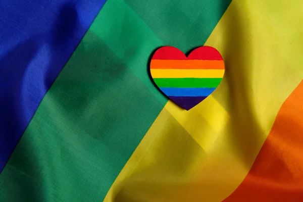 Vista de cerca de la bandera del orgullo LGBT con el corazón coloreado en colores de orgullo LGBTQ. Concepto del día de San Valentín, libertad, igualdad — Foto de Stock