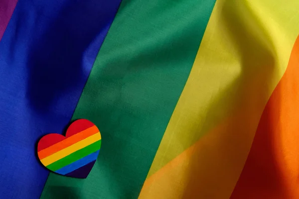 Maqueta hecha con la bandera del orgullo LGBT con el corazón coloreado en colores de orgullo LGBTQ. Concepto del día de San Valentín, libertad, igualdad — Foto de Stock
