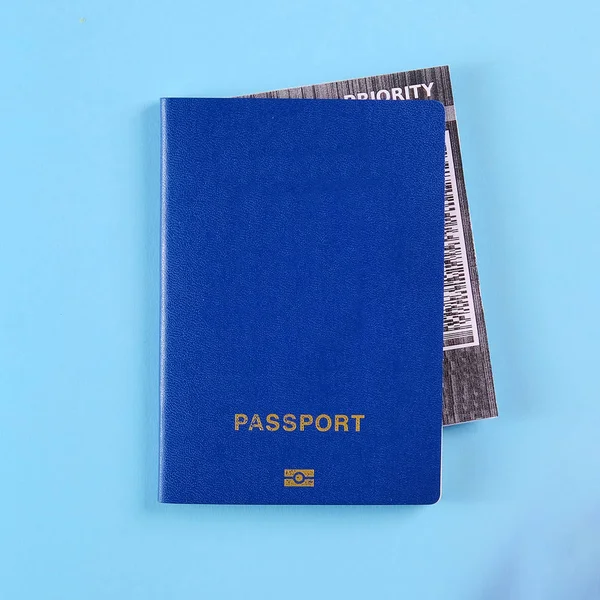Blå internationellt pass med flygbiljett inne på den klarblå bakgrunden. — Stockfoto