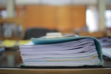 Ofis masası arşivine istiflenmiş tamamlanmamış kağıt işleri belgeleri piyasanın arşivinde inceleniyor ve gelecekte masa ofisinin ne kadar kar getireceğine karar veriliyor..