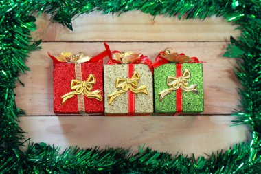 Tahta arka planda hediye kutusu dekorasyonu. Mutlu noel kartları. Kış tatili teması. - Mutlu yıllar. Mesaj için yer var. Üst görünüm.