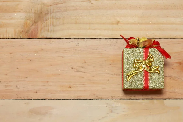 Time gifts - gift box on wood table.Winter holiday theme. Happy New Year. Space for text.