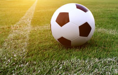 Futbol çim üzerinde top ve bir portakal güneş gibi ışık var.