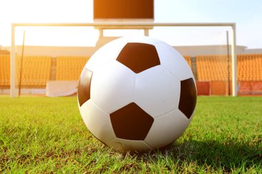 Futbol çim üzerinde top ve bir portakal güneş gibi ışık var.
