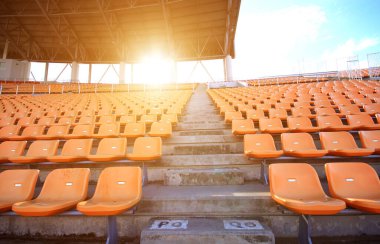 Stadyumlar, boş koltuklar ve güneş gibi turuncu bir ışık..
