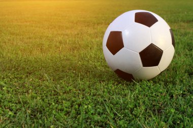 Futbol çim üzerinde top ve bir portakal güneş gibi ışık var.
