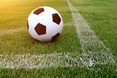 Futbol çim üzerinde top ve bir portakal güneş gibi ışık var.