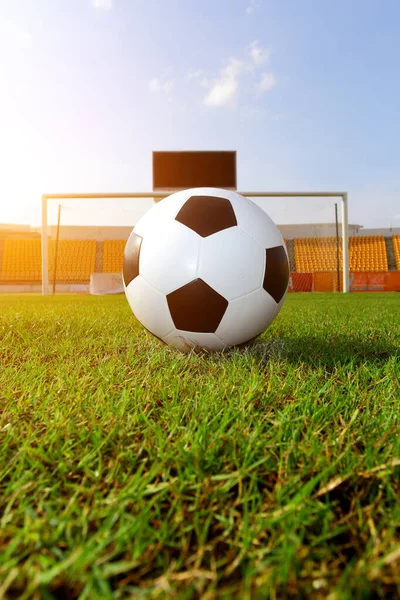 Futbol çim üzerinde top ve bir portakal güneş gibi ışık var.