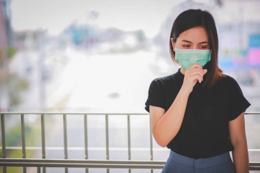 PM2.5 'u korumak için maske takan Asyalı kadın ve Covid-19 virüslü öksürük..