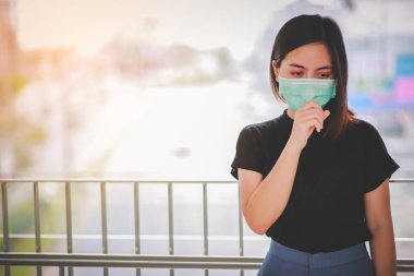 PM2.5 'u korumak için maske takan Asyalı kadın ve Covid-19 virüslü öksürük..