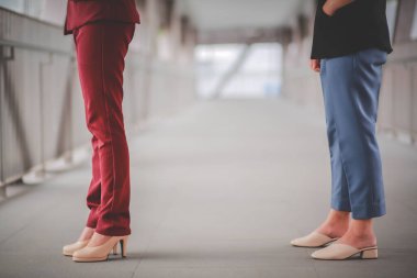 Diğer insanlardan 1 metre uzakta duran iki Asyalı kadın COVID-19 virüslerinden ve enfeksiyon riskine karşı sosyal mesafeyi koruyorlar..