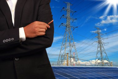 Şehrin arka planında elektrik kutupları ve güneş panelleri olan tanınmayan kişi