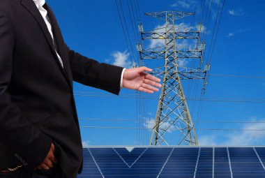 Yüksek voltaj kulelerine karşı güneş paneli olan mühendis..