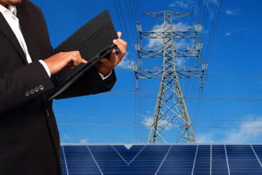 Yüksek voltaj kulelerine karşı güneş paneli olan mühendis..