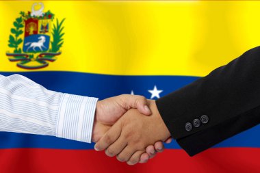 Arkaplan olarak Venezuela bayrağı ile el sıkışmak ya da sözleşmek.