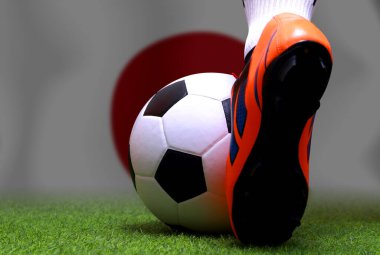 Futbol oyuncusunun bacakları ve ayakları kapalı yeşil çimlerin üzerinde yürür ve ulusal Japonya bayrağının arka planında maç yapmaya hazırdır..
