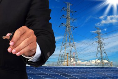 Şehrin arka planında elektrik kutupları ve güneş panelleri olan tanınmayan kişi