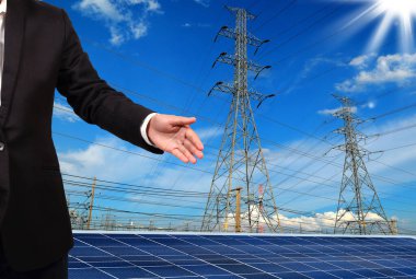 Şehrin arka planında elektrik kutupları ve güneş panelleri olan tanınmayan kişi